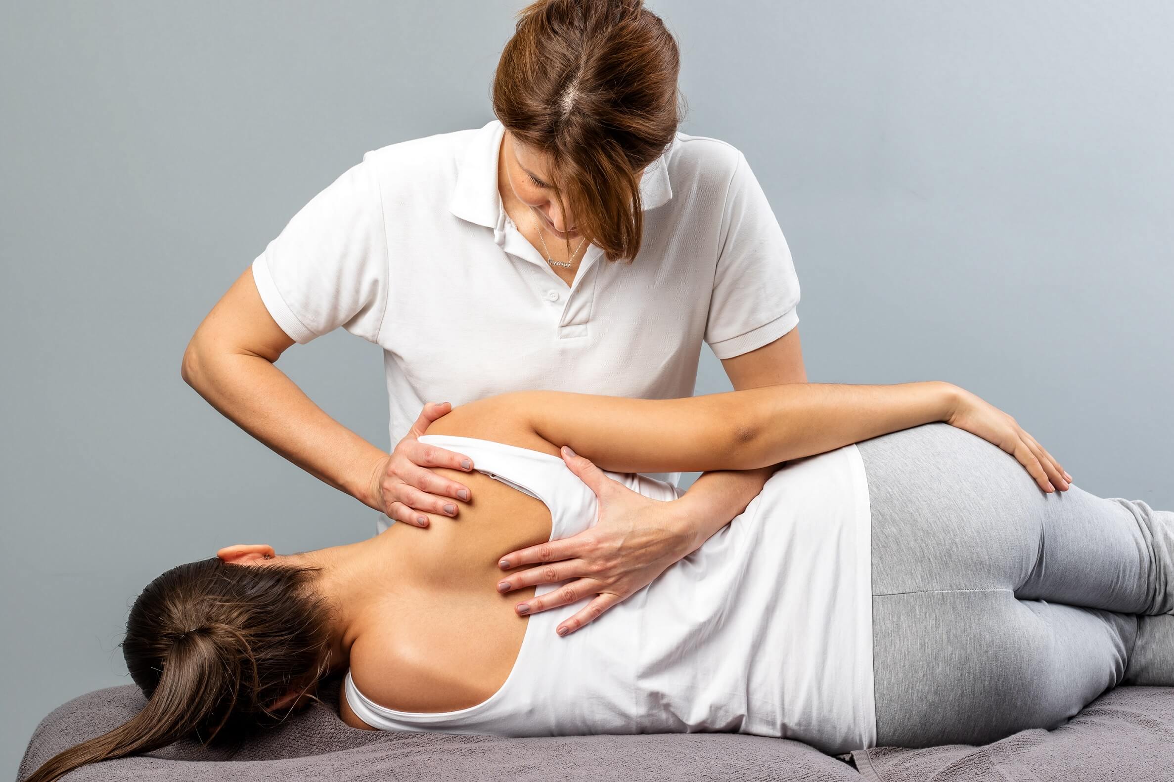 Claudia Gapp Osteopathie in der Praxis bei der Behandlung am Rücken einer Patientin.